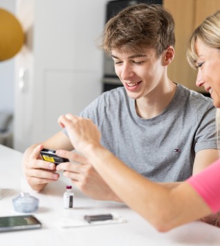 Young person and pump trainer looking at the t:slim X2 insulin pump